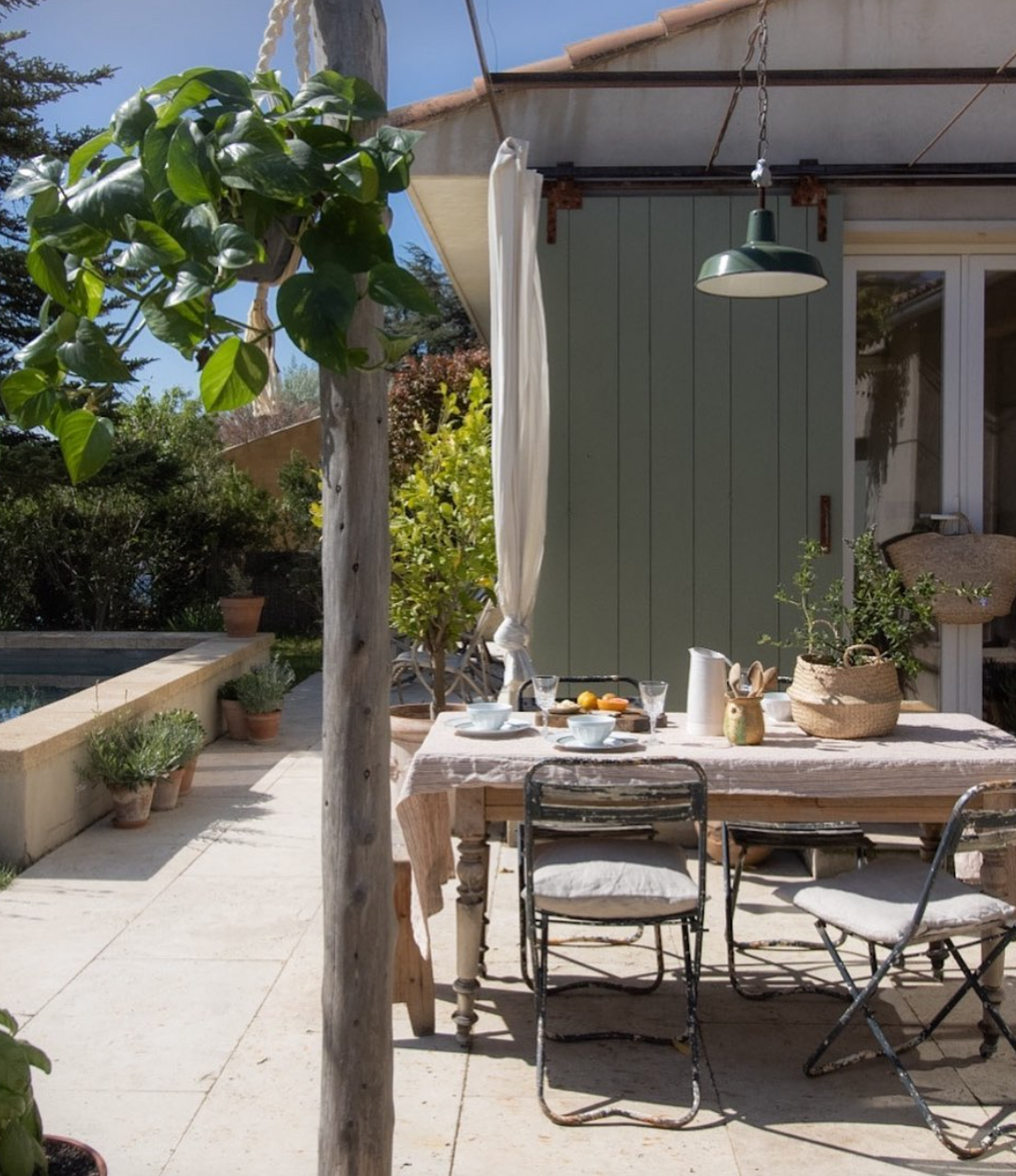 pretty outdoor dining area styled with vintage furniture, accessories and plants. 