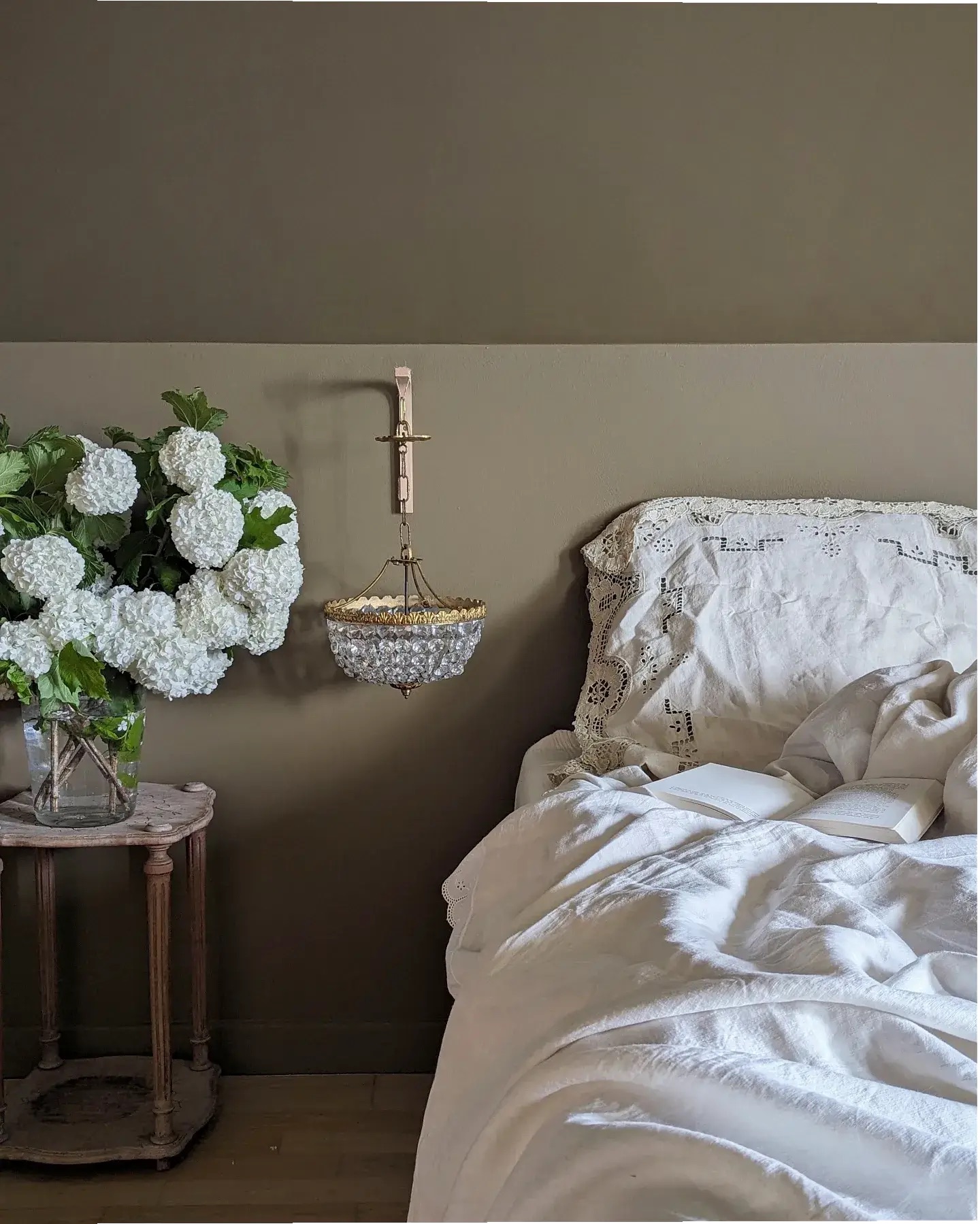 bedroom in muted colour palette with vintage bedside lamp