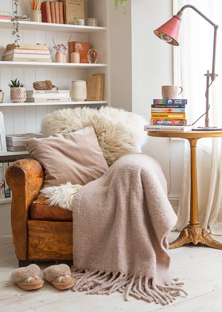 Cosy corner with muted pink blanket, sheepskin throw and sheepskin slippers The Small Home