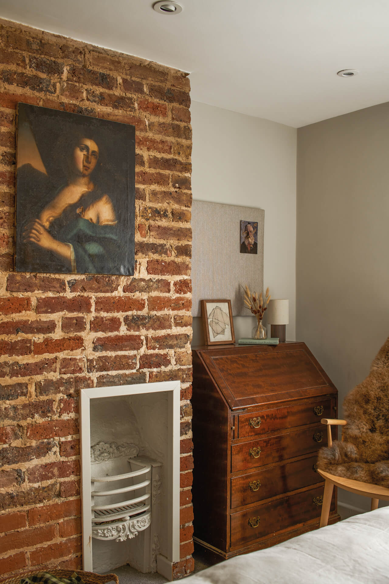 corner of a bedroom with exposed brick wall and vintage decor. 